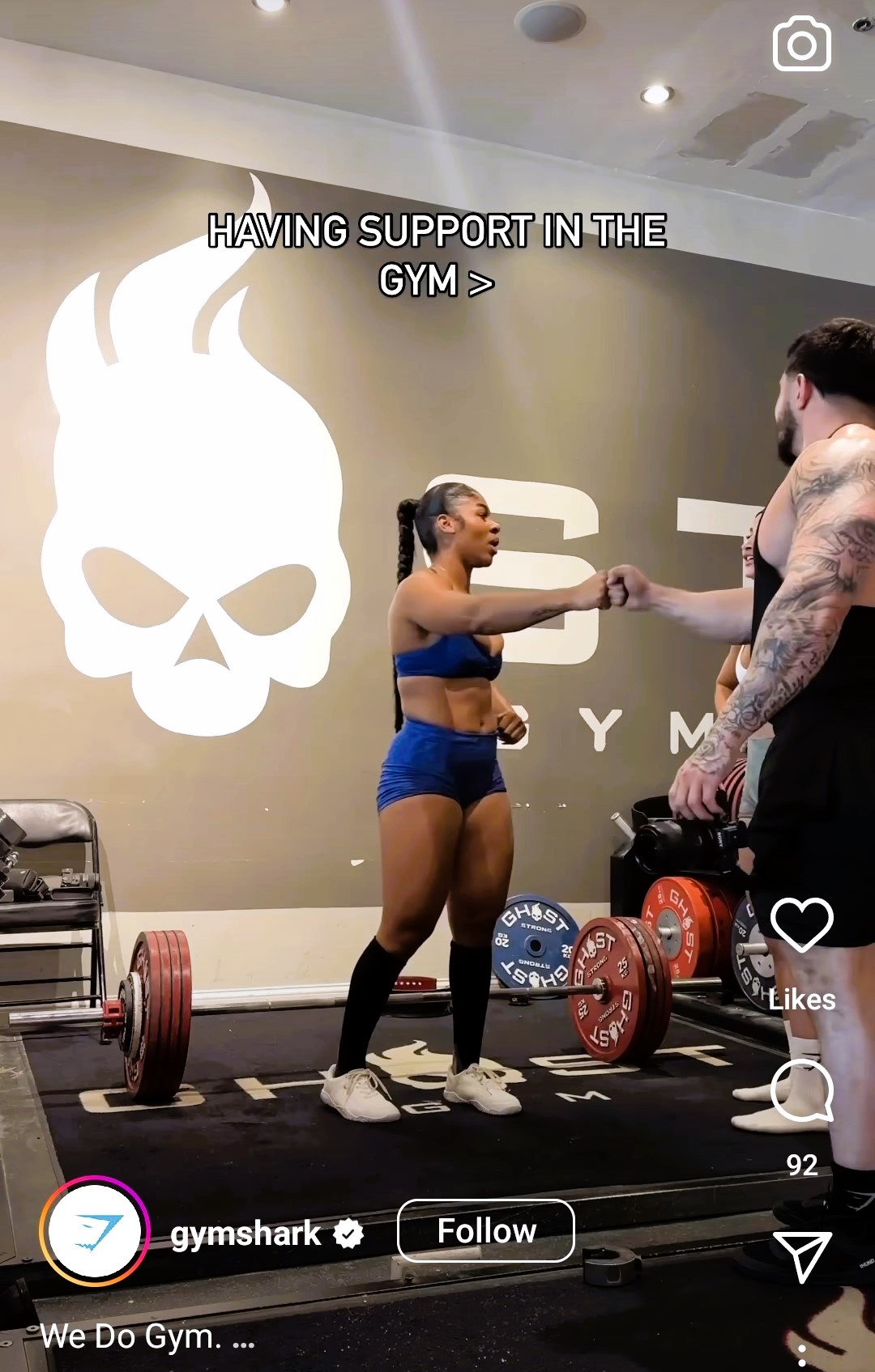 Gymshark Instagram reel still featuring individuals fist-bumping after weight training.